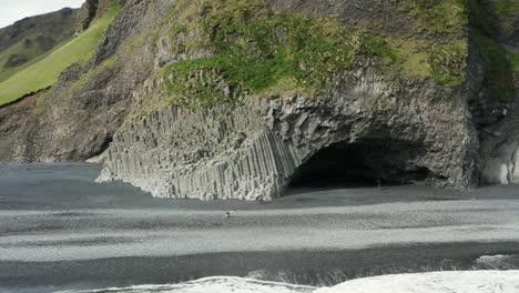 famous basalt pillar caves in iceland shore at reynisfjara beach, aerial