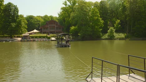 Boat-Across-The-Waters-Leading-To-Chalet-Robinson-In-Bois-de-la-Cambre,-Robinson-Island-In-Brussels,-Belgium