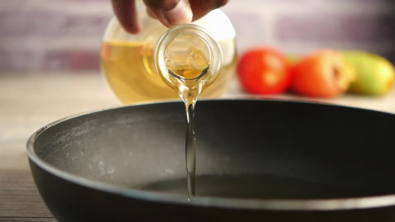 Pouring oil into a pan for cooking