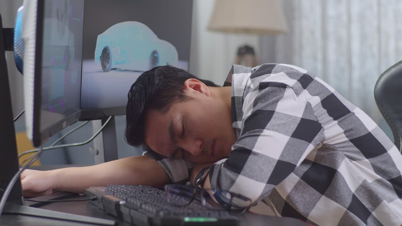 Tired designer takes a nap at their desk