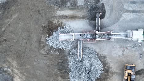 tiro de drone de cinta transportadora clasificando rocas y escombros en montones en mina de cantera
