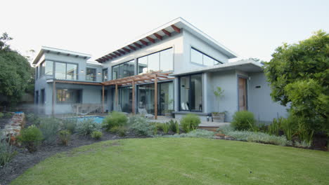modern house with large windows and lush garden in residential area, copy space