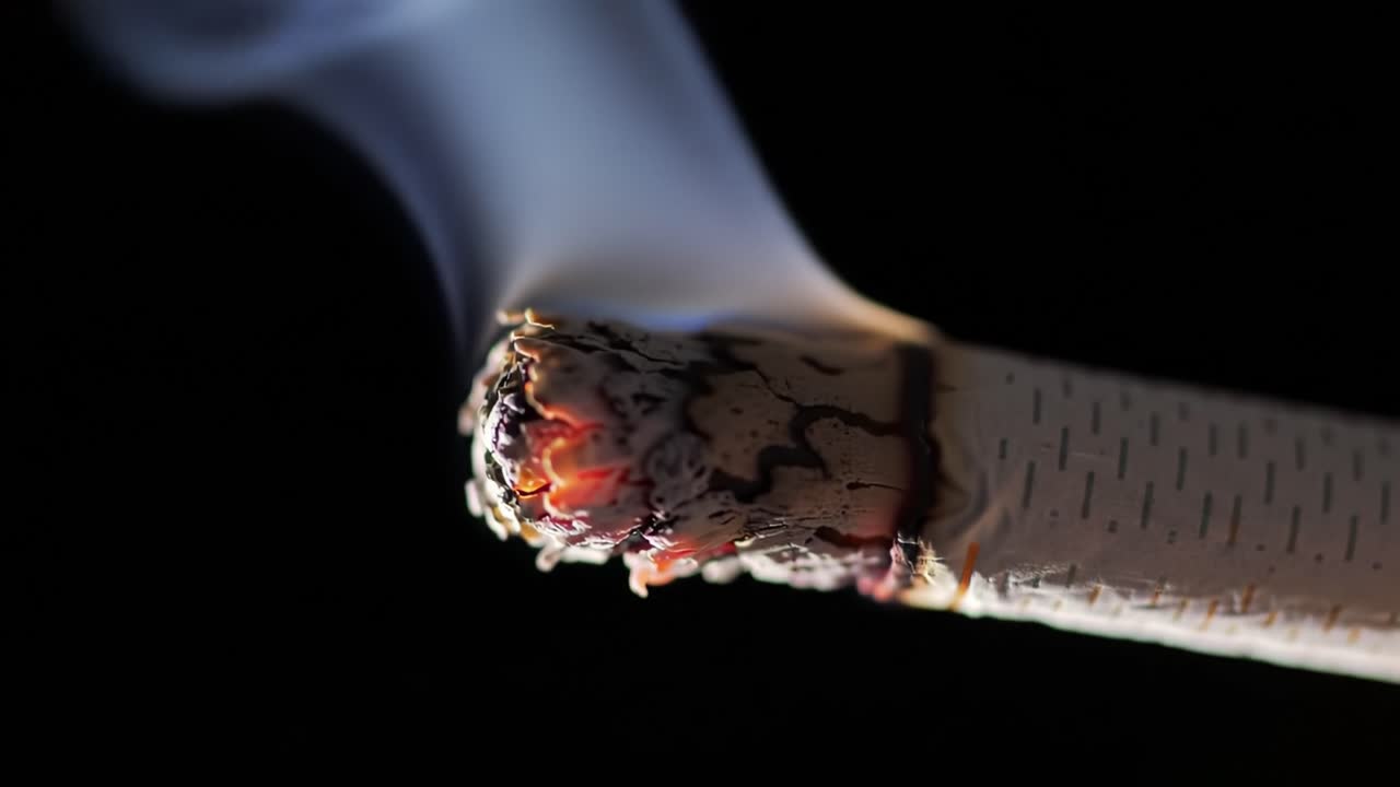 A Crucial Transformation: The Visual Journey of a Cigarette from Ember to Flame Captured in Two Powerful Frames of a Smoking Sequence