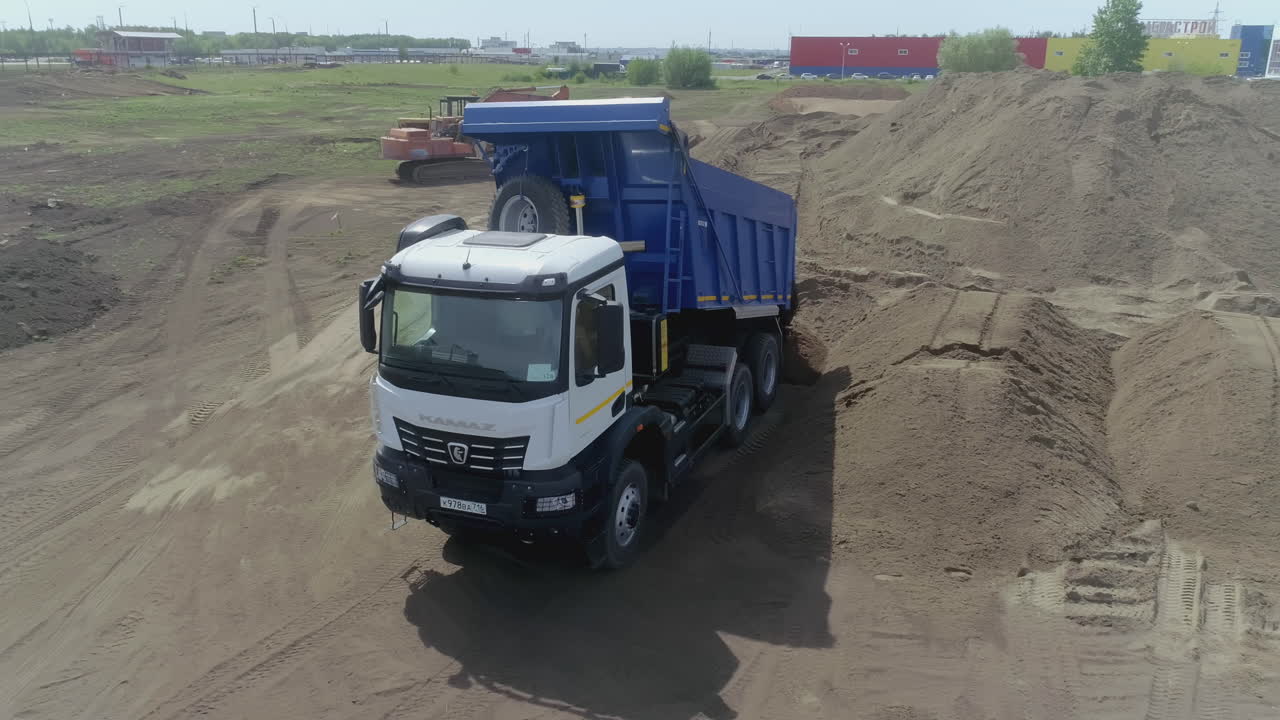 KamAZ-kippiauto lastaamassa hiekkaa rakennustyömaalla