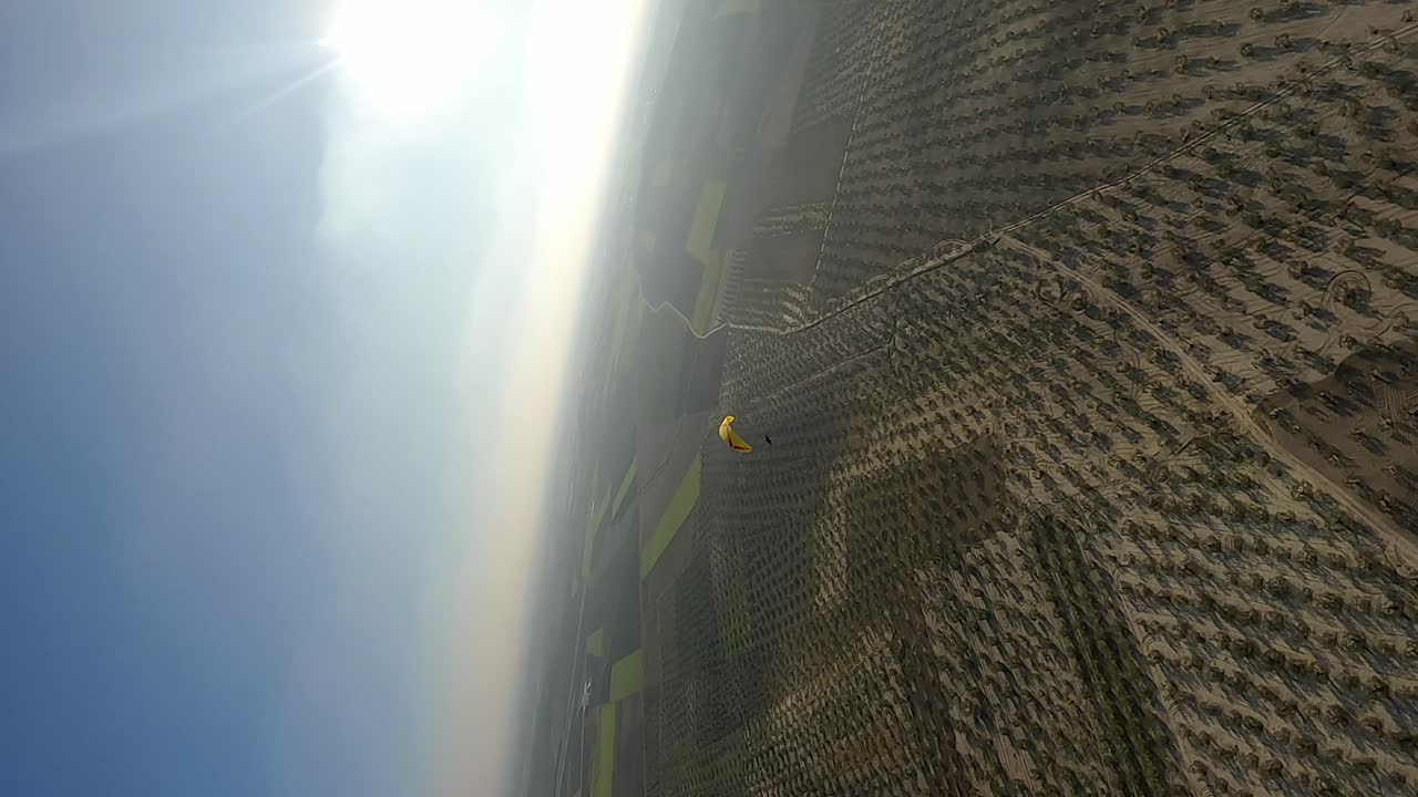 formato vertical: círculos aéreos parapente volando sobre olivares