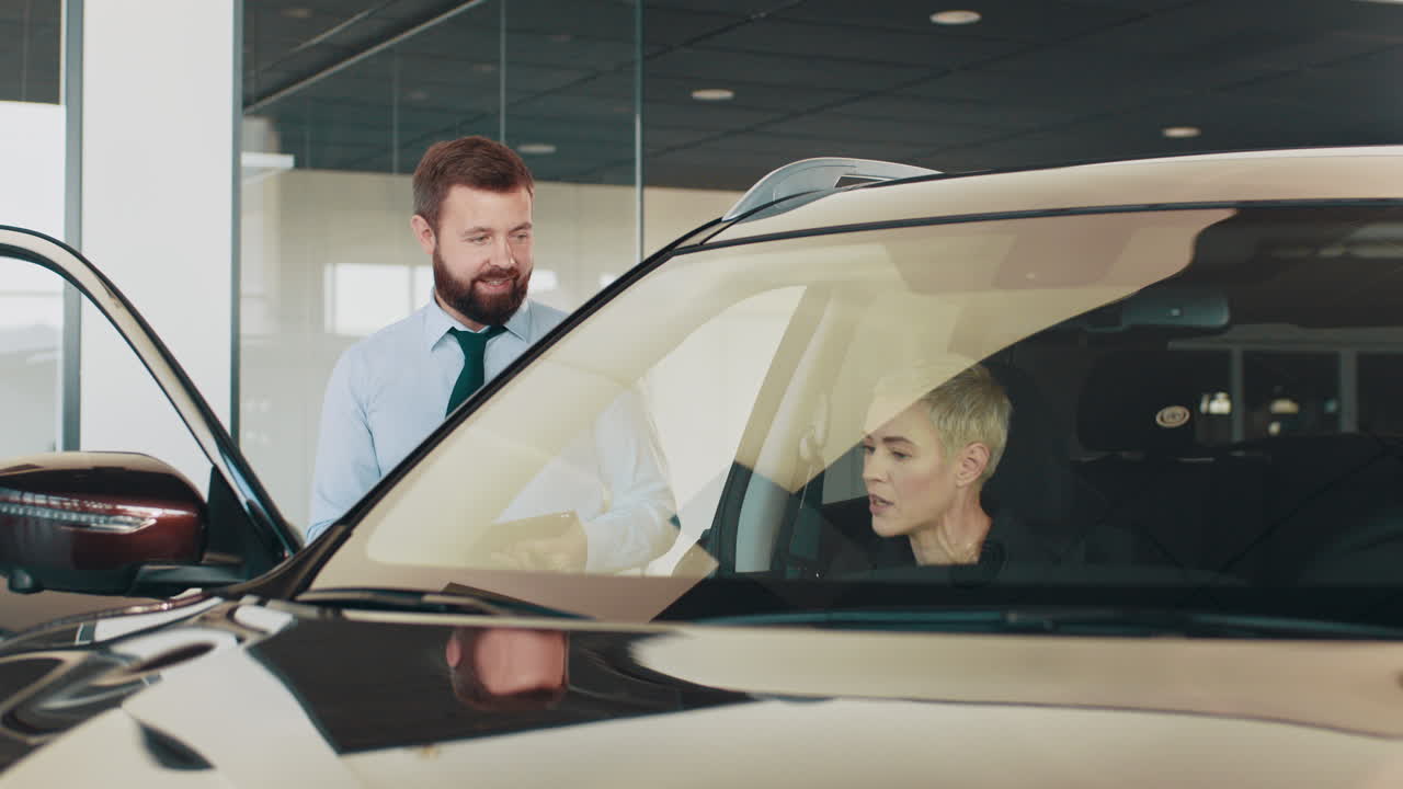 vendedor de coches discutiendo un coche con un cliente en una sala de exposiciones