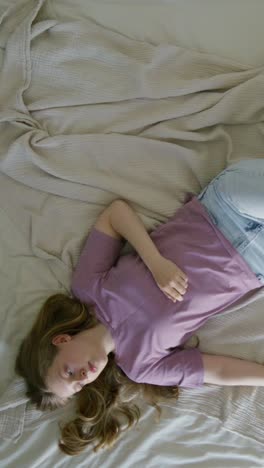 teenage girl resting on a bed