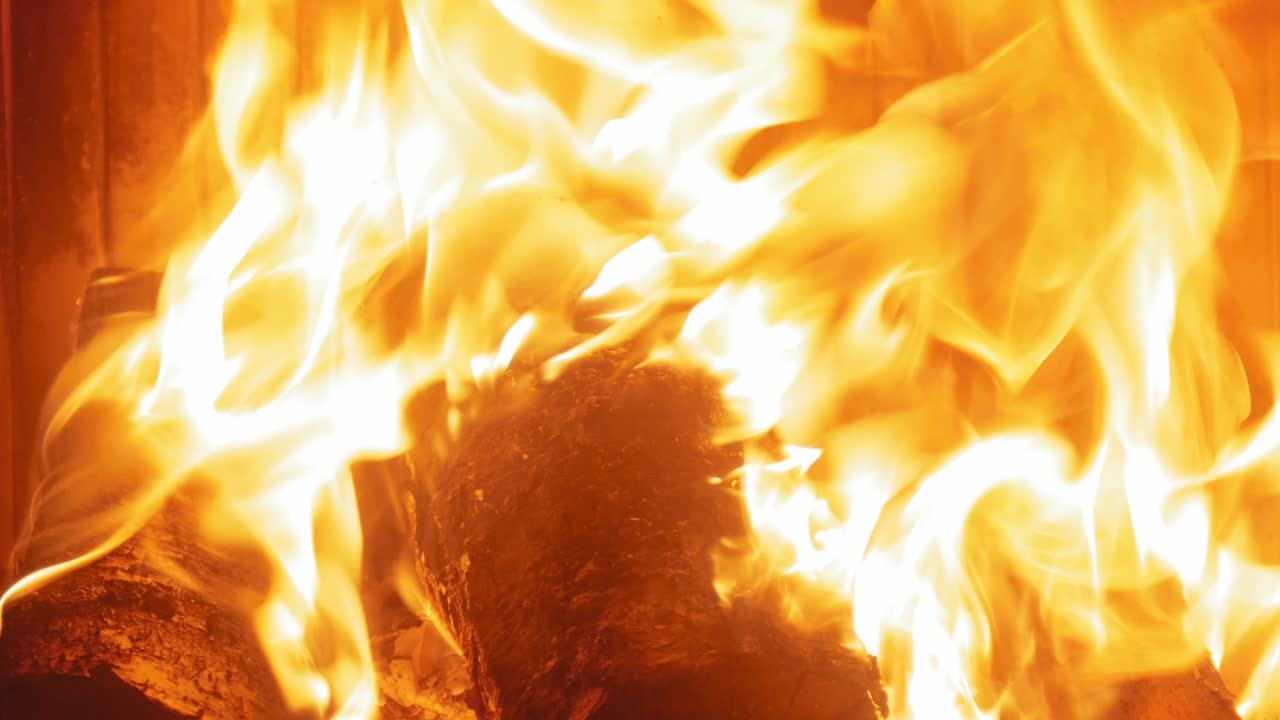 llama ardiente en la chimenea en troncos de madera