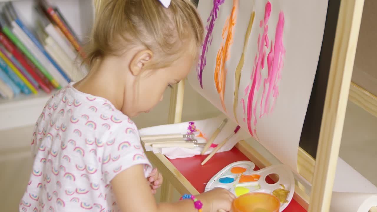 그녀의 그림을 위해 페인트를 혼합하는 귀여운 소녀