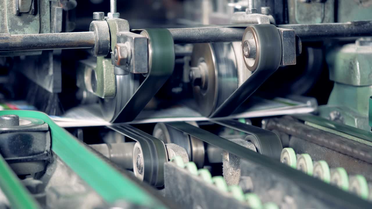 un primer plano de una máquina de corte de fábrica que corta las caras de los periódicos