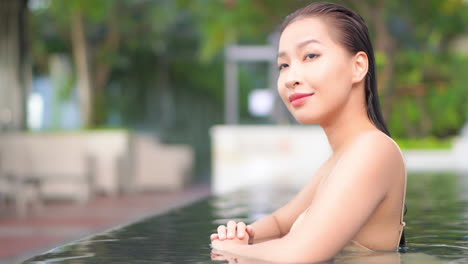 Close-up-profile-of-a-very-attractive-woman-in-a-swimming-pool-as-she-turns-her-head-toward-the-camera