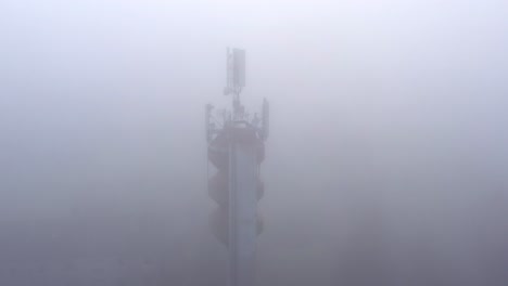 mobile network antennas on a water tower, transmitting in bad weather, aerial view