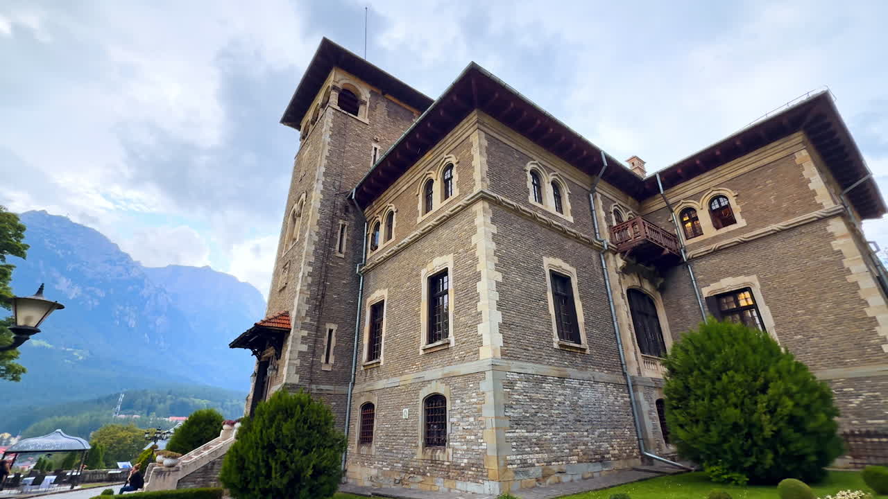 Busteni, Romania, 17 July 2025: Cantacuzino Castle exterior in Busteni, Romania. Approaching the building on a rainy day. Cloudy sky at backdrop