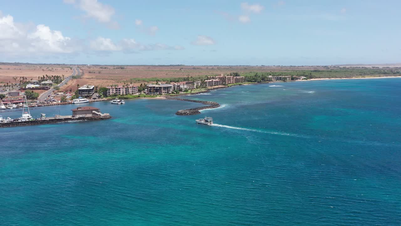 Aerial wide tracking shot of a boat entering the marina at Maalaea Harbor in West Maui, Hawai'i