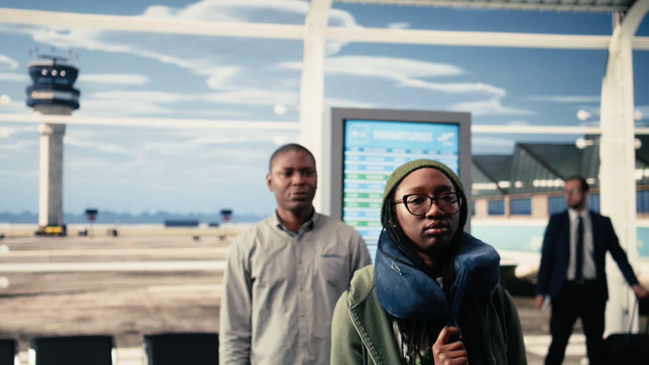 Portrait of travelers waiting at departures lounge in busy airport terminal