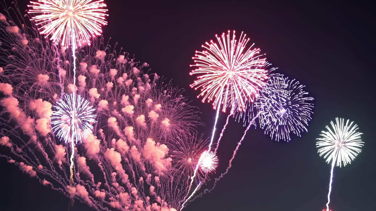 Bright and colorful fireworks bursting against the dark night sky, illuminating the atmosphere with vibrant hues and creating a festive mood during evening celebrations and joyful events