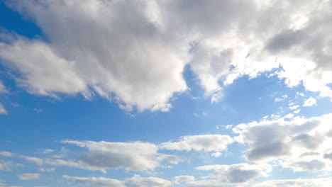 Stunning azure sky with brightly shining sun and soft cloudscape. White fluffy clouds quickly changing shapes in the atmosphere. Timelapse.
