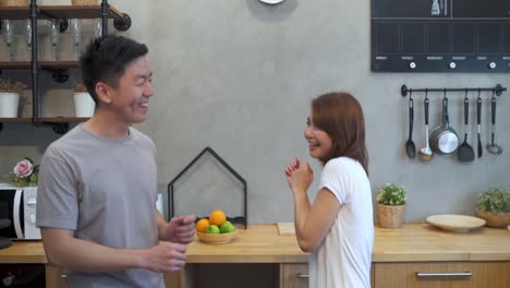 beautiful happy asian couple are dancing in the kitchen at home. young asian couple have romantic time while listening music at home.