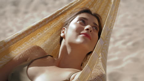 closeup chica relajándose hummock en la luz del sol de verano. mujer despreocupada descansando playa