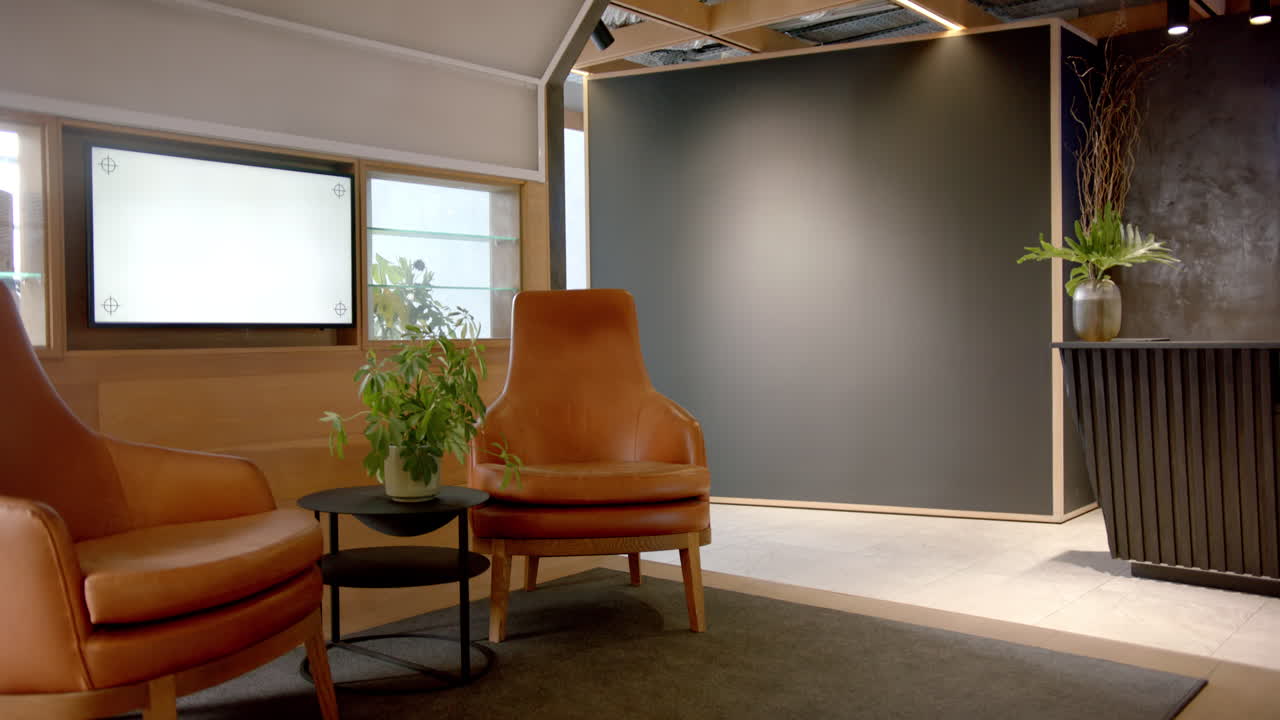 Modern office lobby with leather chairs, plants, and reception desk, copy space