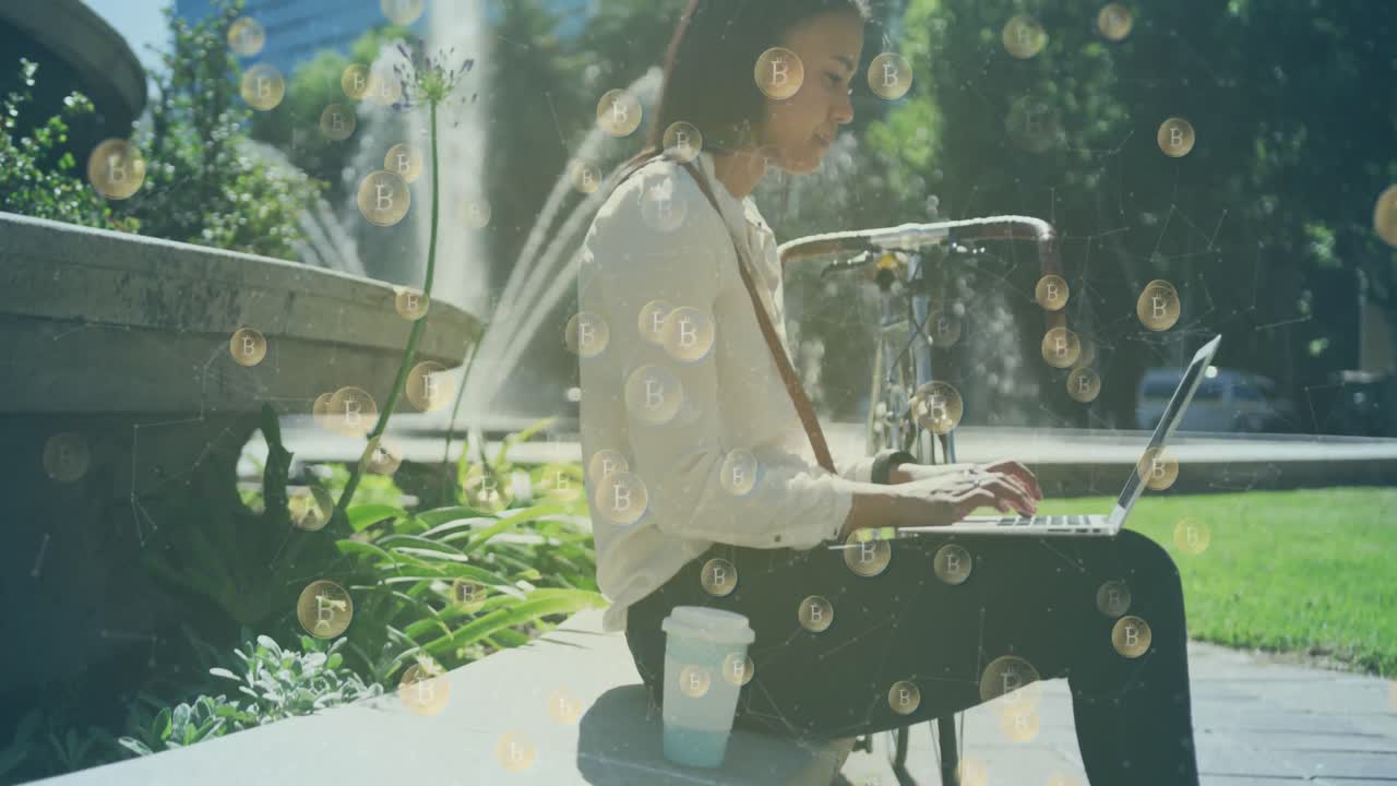 공원에서 노트북을 사용하는 여성 위에 비트코인 아이콘의 애니메이션