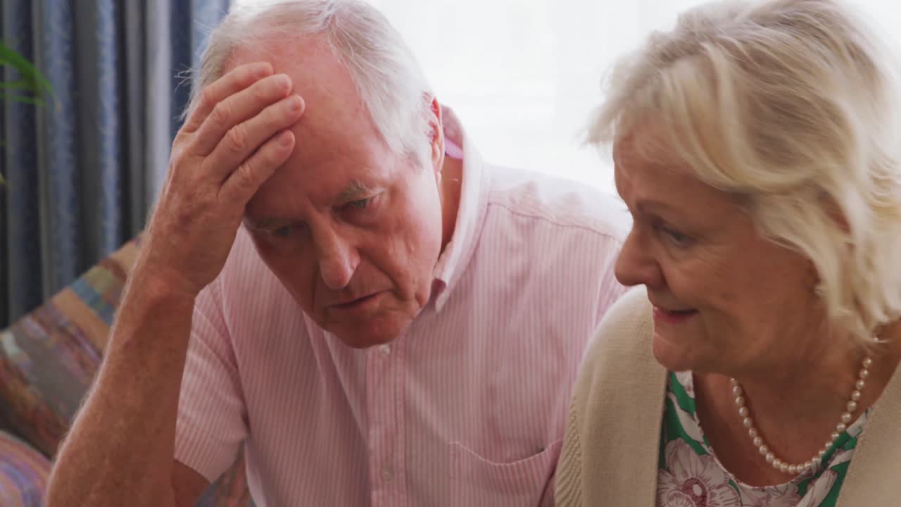 Senior couple in social distancing using laptop