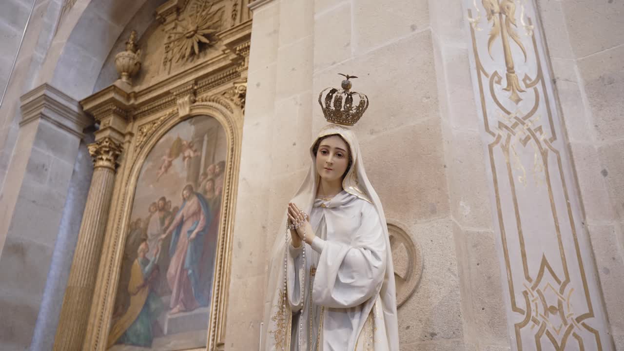 Elegant Virgin Mary statue with crown and rosary, radiating peace in sacred surroundings