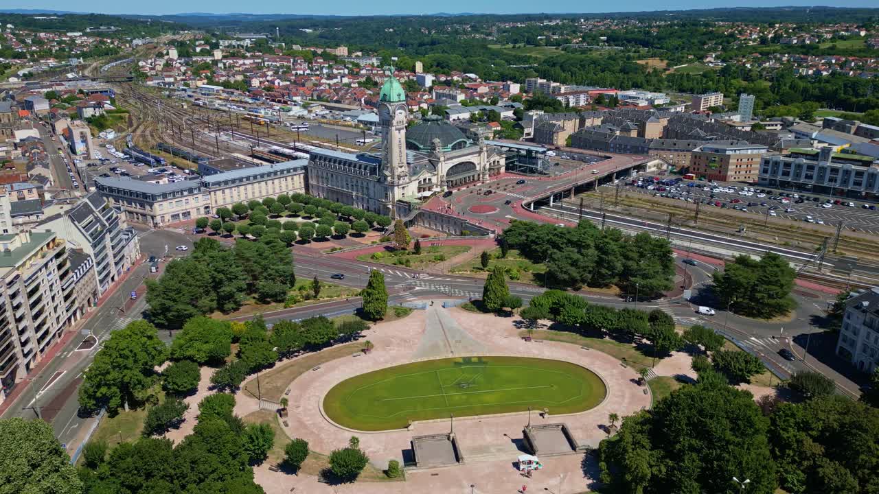 Rail station and park area in Limoges seen from above, sunny day with surrounding buildings, panoramic establish drone