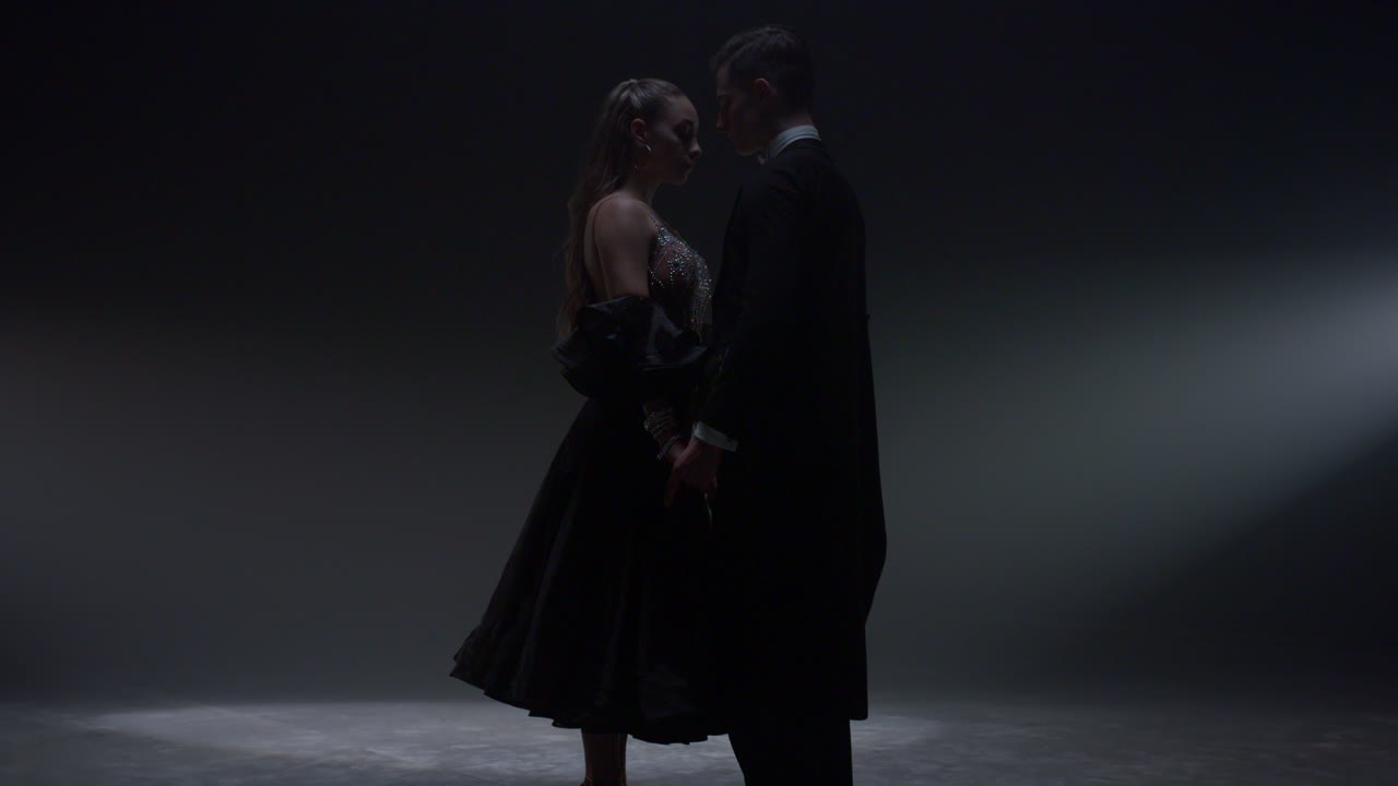 bailarines tiernos de salón de baile de pie en el escenario. una hermosa pareja de baile unida de manos