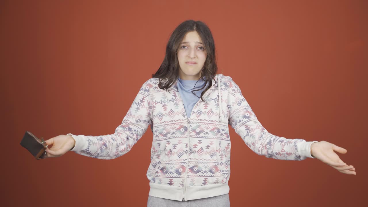 빈 지갑을 바라보는 빈곤한 젊은 여성.