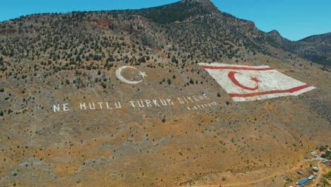 aerial shot of massive painted turkish flag on mountain in cyprus