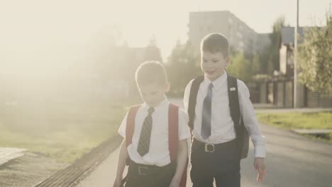 cu tracking slow motion two schoolchildren go home after school they talk smile