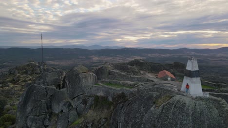 One-person-on-walls-of-Monsanto-castle-at-sunrise,-Portugal