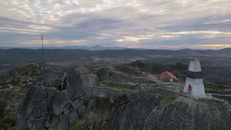 una persona en las paredes del castillo de monsanto al amanecer, portugal