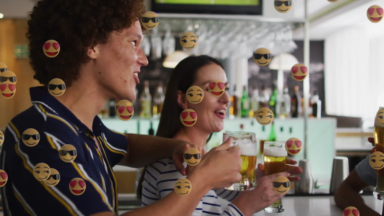 Four friends clinking beer mugs in bar marketing with overhead glasses featuring floating emojis