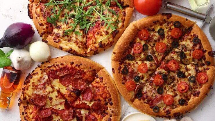 Tre pizze in stile americano servite su un tavolo