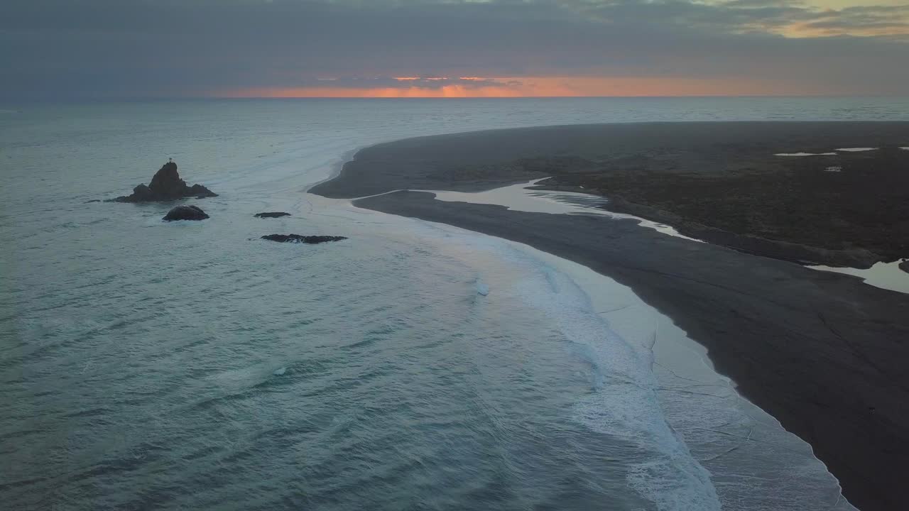 Sunset behind Whatipu Beach in the Auckland region of New Zealand