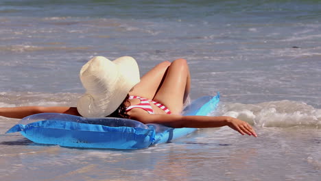 Mädchen-Sonnt-Sich-Auf-Einer-Luftmatratze-Am-Strand-Und-Wird-Von-Den-Wellen-Nassgespritzt