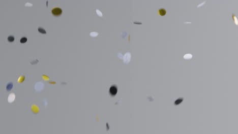 stationary shot of silver and gold confetti falling against grey background