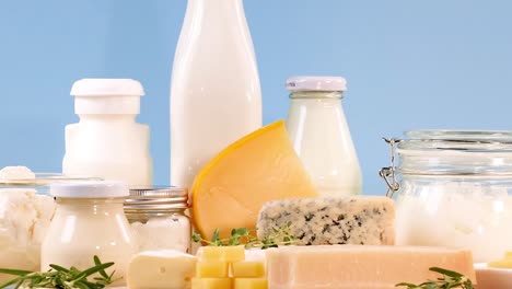 A variety of dairy products including milk, cheese, and yogurt displayed against a blue backdrop.