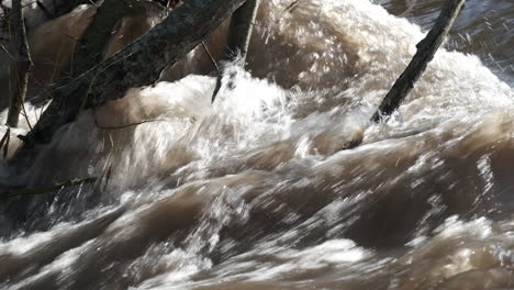 The fast flowing water of the river Arrow running through Warwickshire, England after heavy rainfall raised the river level