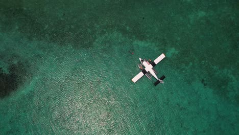 Seaplane-parking-on-calm-blue-waters-of-crystal-clear-indian-ocean-in-maldives-Kuredu-island-resort-drone-shot