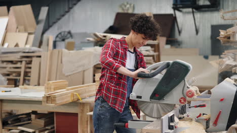 woman carpenter working with a saw in a workshop