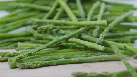 Lanza-De-Espárragos-Verdes-Rodando-Sobre-La-Superficie-Blanca-De-La-Cocina-Dieta-De-Alimentos-Vegetales-Verdes-Naturales-Y-Saludables