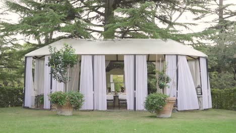 de estructura abierta de gazebo establecida con mesa establecida lista para el almuerzo de la ceremonia de boda bajo un pino del bosque