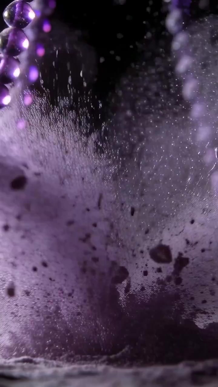 Vertical video: Erupting after pulse, purple powder sending cloud across studio set, beads settling