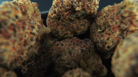 a macro close up cinematic detailed shot of a cannabis plant, orange hybrid strains, indica and sativa , dark purple marijuana flower, on a rotating stand, slow motion, 4k, professional studio light