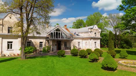 aerial view of babtyno manor, a historic estate surrounded by lush greenery, featuring classic architecture and a well-kept garden. themes related to history, heritage, and countryside estates.