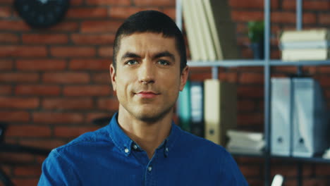 close up of the handsome man looking and smiling to the camera in the urban office room