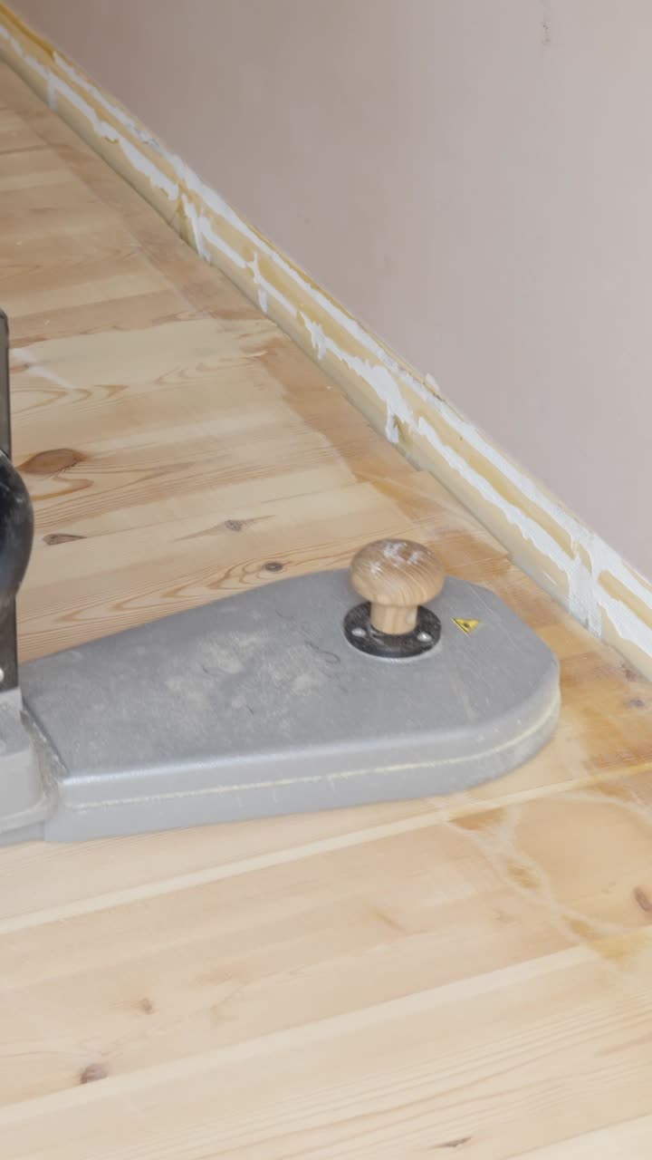 Home renovation process. Sanding wooden floor edges with a power sander
